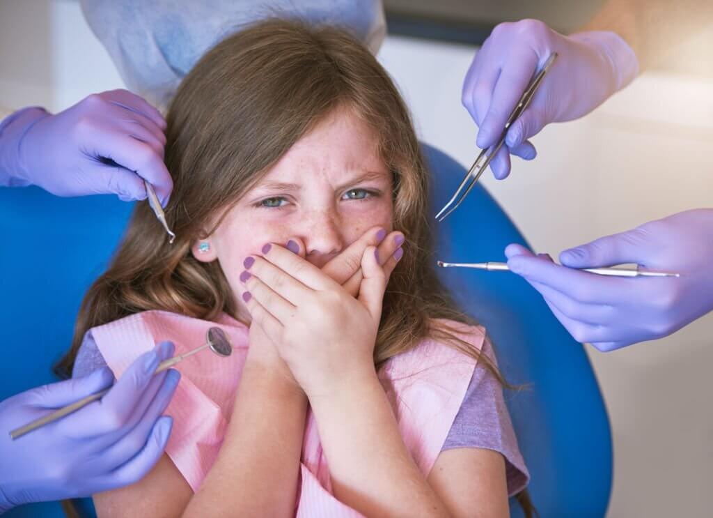Dentist checking womens teeth with dental implant model