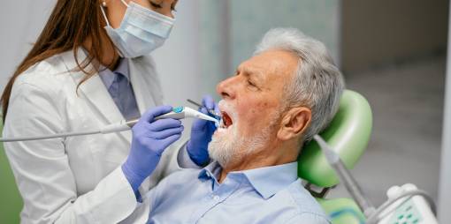 Dentist working on the teeth of senior patient