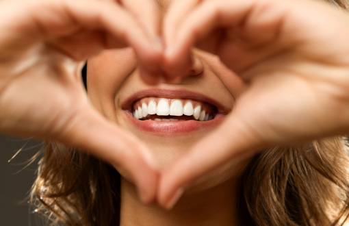 woman making a heart shape with a beautiful smile